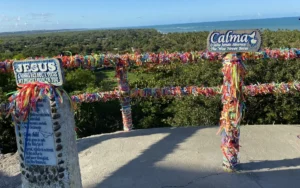 Mirante da Igreja de Nossa Senhora d'Ajuda em Arraial d'Ajuda, com fitinhas coloridas e vista panorâmica para as melhores praias e o mar azul da Bahia.