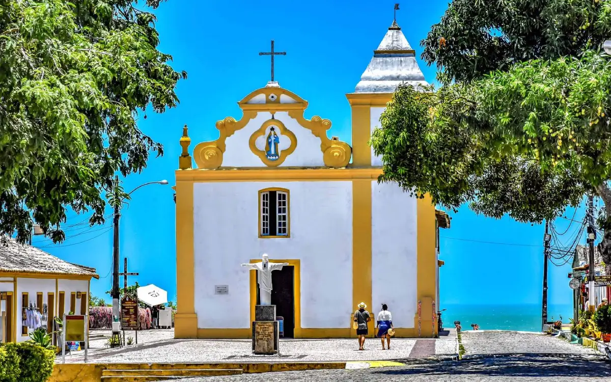 A histórica Igreja Nossa Senhora d'Ajuda, um dos marcos mais charmosos de Arraial d'Ajuda, Bahia. Do seu mirante, aprecie a deslumbrante vista para o mar
