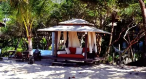 Quiosque de descanso sofisticado em madeira e tecido na areia da Praia dos Nativos em Trancoso o que fazer.