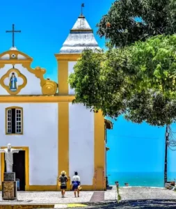 Igreja Nossa Senhora d'Ajuda em Arraial d'Ajuda com vista para o mar azul.
