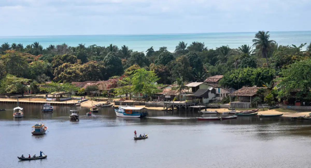 A travessia de canoa sobre o Rio Caraíva é a porta de entrada para o vilarejo, um dos pontos mais charmosos do roteiro arraial caraiva trancoso no Sul da Bahia.