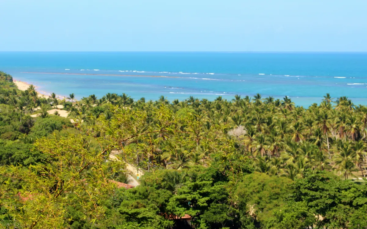 Passeio Trancoso Arraial d'Ajuda saindo de Porto Seguro: vista aérea do Quadrado de Trancoso com igreja e coqueiros ao entardecer.