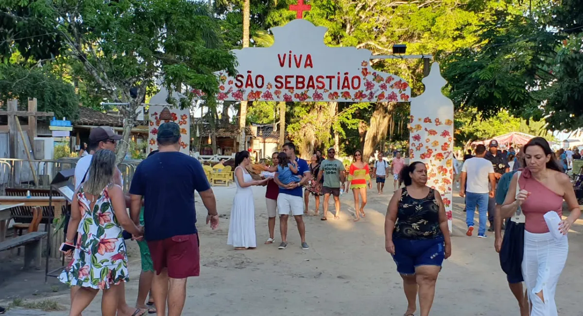 Multidão e decoração festiva na entrada do Quadrado de Trancoso, marcando a importância da Trancoso Festa Folclórica de São Sebastião para a comunidade local.