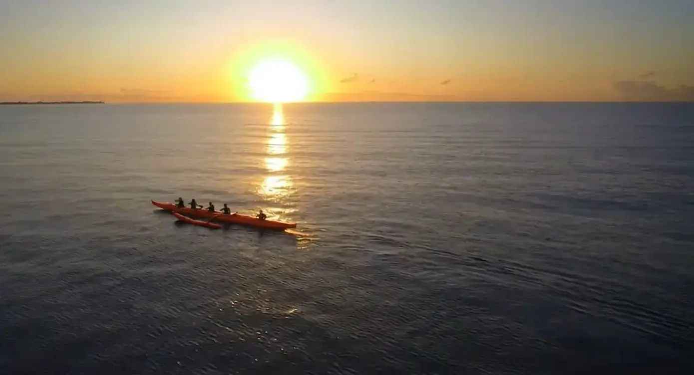 Canoeiro pratica canoagem havaiana ao nascer do sol na Praia de Taperapuã, em Porto Seguro.